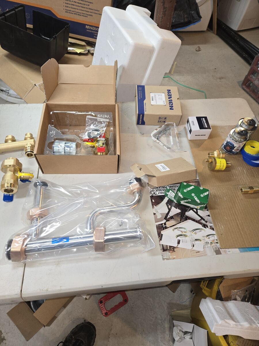 Fittings, valves and manifold parts laid out on a work table before installation